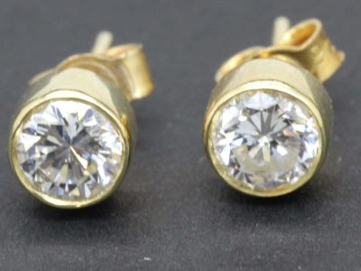 Gold and diamond stud earrings with sparkling gemstones for women.