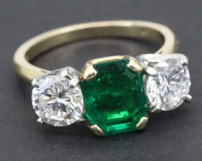 Elegant emerald and diamond ring with gold band.
