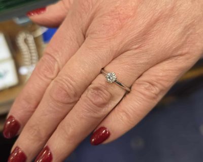 Close-up of a diamond engagement ring on a woman's finger.
