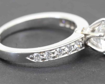 Silver engagement ring with a large central diamond and smaller side stones, showcasing fine craftsm.
