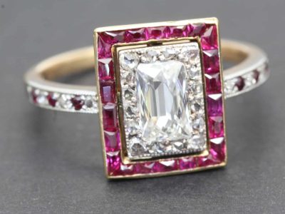 Elegant diamond ring featuring an emerald-cut center stone surrounded by pink gemstones and a diamon.