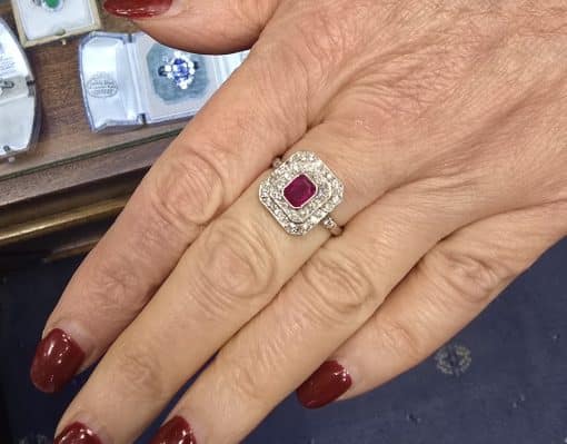 Ruby and diamond ring on a woman's finger, showcasing fine jewelry craftsmanship.