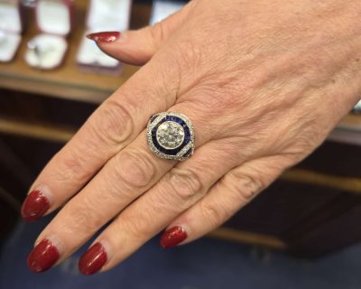 Elegant diamond and sapphire ring with intricate design, perfect for special occasions.