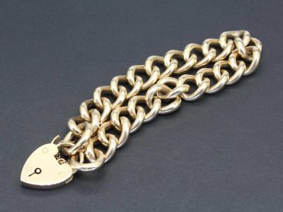 Elegant rose gold curb chain bracelet with a heart-shaped padlock charm. Perfect for stylish jewelry.