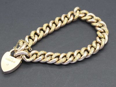 Gold and silver chain bracelet with a heart-shaped padlock charm, perfect for elegant jewelry collec.
