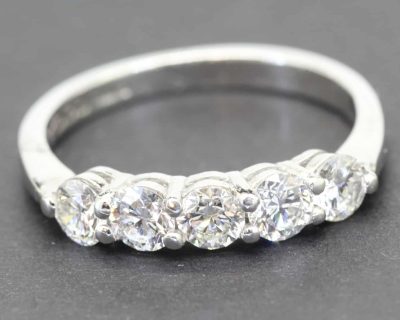 Diamond ring with multiple sparkling stones on a silver band.