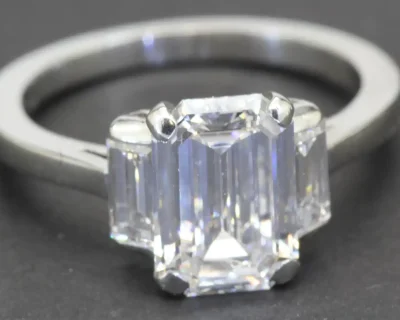 Elegant emerald-cut diamond ring with a sleek silver band, perfect for engagement or special occasio.