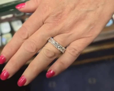 Diamond engagement ring with sparkling stones on a woman's finger.