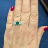 Main photo of Colombian emerald and diamond three stone ring on a hand