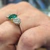 Profile view of emerald ring on a hand