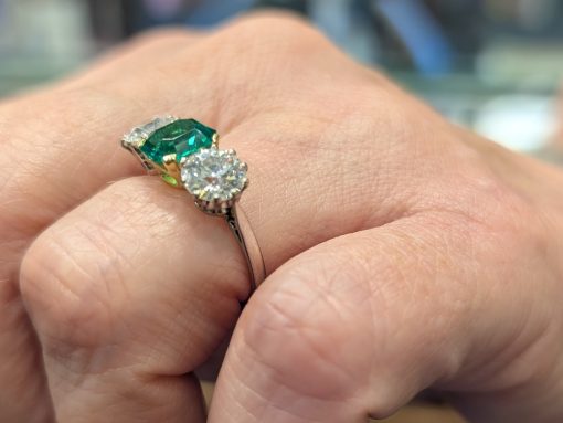 Profile view of emerald ring on a hand