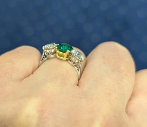 Side view of emerald ring on a hand
