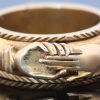 A rare and evocative Georgian “Mane in Fede” memorial ring, made in 1774. The name Mane in Fede refers to the traditional motif of two clasped hands, symbolising faith, fidelity and enduring affection. Memorial rings of this type formed an intimate connection between jewellery and remembrance, often incorporating a lock of the deceased’s hair as a tangible keepsake. This example is particularly intriguing for its ingenious concealed compartment.