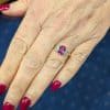 Pink sapphire and diamond three stone ring, view on hand