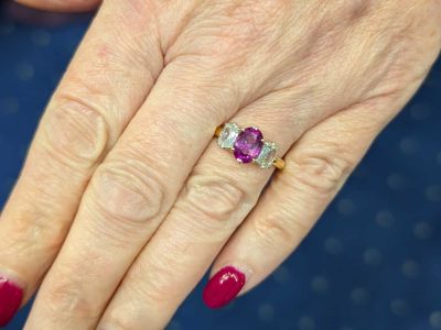 Pink sapphire and diamond three stone ring, view on hand