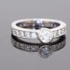 Elegant and contemporary in style, this diamond ring combines the clean lines of a bezel setting with the enduring brilliance of diamonds. Its refined design balances the prominence of the central stone with the delicate sparkle of diamond-set shoulders, creating a sophisticated addition to a fine jewellery collection.