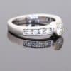 Elegant and contemporary in style, this diamond ring combines the clean lines of a bezel setting with the enduring brilliance of diamonds. Its refined design balances the prominence of the central stone with the delicate sparkle of diamond-set shoulders, creating a sophisticated addition to a fine jewellery collection.
