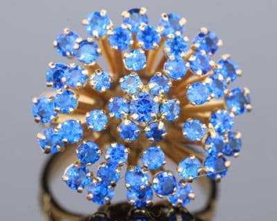 A wonderfully distinctive gem-set dress ring, featuring a dramatic sunburst design that celebrates bold colour and sculptural form. Its generous domed profile and radiating arrangement evoke the glamour of statement jewellery, creating a piece with striking visual impact and individual character.