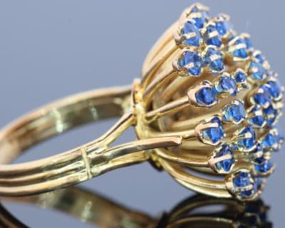 A wonderfully distinctive gem-set dress ring, featuring a dramatic sunburst design that celebrates bold colour and sculptural form. Its generous domed profile and radiating arrangement evoke the glamour of statement jewellery, creating a piece with striking visual impact and individual character.