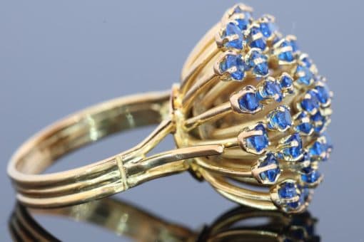 A wonderfully distinctive gem-set dress ring, featuring a dramatic sunburst design that celebrates bold colour and sculptural form. Its generous domed profile and radiating arrangement evoke the glamour of statement jewellery, creating a piece with striking visual impact and individual character.