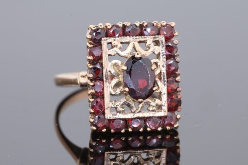 Elegant and richly detailed, this garnet panel ring combines the warm lustre of gold with the deep red tones of garnets. Its decorative filigree work lends the piece a distinctive character, showcasing the enduring appeal of intricate jewellery craftsmanship.