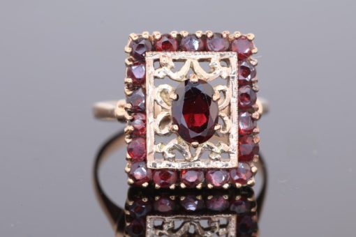 Elegant and richly detailed, this garnet panel ring combines the warm lustre of gold with the deep red tones of garnets. Its decorative filigree work lends the piece a distinctive character, showcasing the enduring appeal of intricate jewellery craftsmanship.