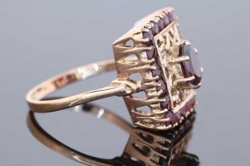 Elegant and richly detailed, this garnet panel ring combines the warm lustre of gold with the deep red tones of garnets. Its decorative filigree work lends the piece a distinctive character, showcasing the enduring appeal of intricate jewellery craftsmanship.