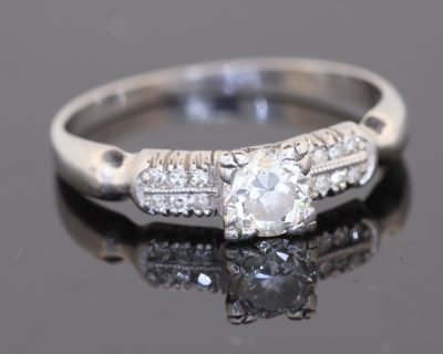 A rare antique diamond ring by Blackensee & Co. of England, dating to circa 1930. Reflecting the elegance of the period, this beautifully detailed jewel combines a central diamond with diamond-set shoulders, creating a sophisticated design with enduring appeal.