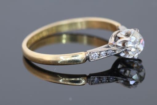 This antique diamond engagement ring combines the romantic appeal of a cushion-cut diamond with the enduring warmth of 18kt gold. Its classic design, enhanced by pavé-set shoulders, offers an elegant balance of character and sparkle.
