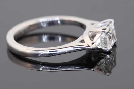 A distinctive three-stone diamond ring that combines geometric elegance with the enduring appeal of platinum. The contrast between a princess-cut centre diamond and trilliant-cut shoulders creates a sophisticated design with crisp lines and a contemporary edge.