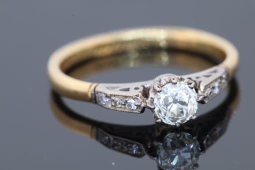 Dating to the antique period, this diamond engagement ring brings together the romantic character of an old-cut diamond and the enduring elegance of 18kt gold. Its classic design, enhanced by pavé-set shoulders, offers a beautiful expression of antique-inspired craftsmanship and timeless appeal.