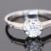 This Art Deco diamond engagement ring captures the elegance and geometric sophistication of the period. Combining a brilliant-cut centre diamond with baguette-cut shoulders and intricate engraved details, it is a distinctive jewel that celebrates the craftsmanship and design sensibility associated with Art Deco jewellery.
