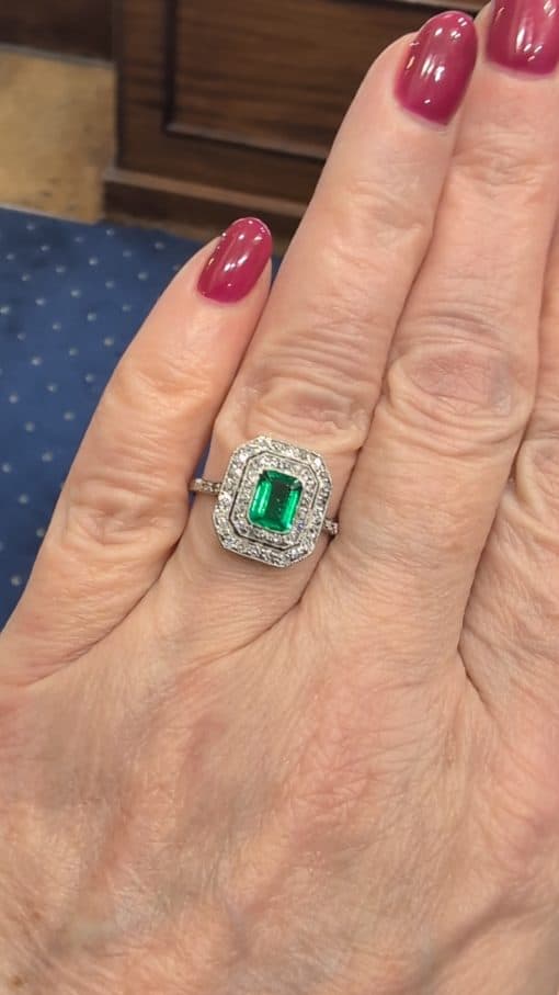 A beautiful Belle Époque emerald and diamond cluster ring, made in France circa 1910 and showcasing the period’s love of delicate platinum construction, fine diamonds and richly coloured gemstones. At its centre is a superb 1-carat Colombian emerald, surrounded by a double halo of diamonds that enhances the stone’s natural colour and gives the ring an elegant, balanced appearance.