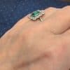 A superb Edwardian emerald and diamond ring, dating to circa 1905 and set in platinum. At its centre is a magnificent 1.5-carat step-cut emerald, distinguished by its exceptional colour and framed by a graceful surround of antique-cut diamonds. The combination of vivid emerald and the cool brilliance of platinum is quintessentially Edwardian, creating a jewel of considerable elegance and character.
