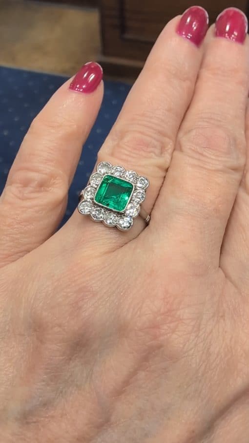 A superb Edwardian emerald and diamond ring, dating to circa 1905 and set in platinum. At its centre is a magnificent 1.5-carat step-cut emerald, distinguished by its exceptional colour and framed by a graceful surround of antique-cut diamonds. The combination of vivid emerald and the cool brilliance of platinum is quintessentially Edwardian, creating a jewel of considerable elegance and character.