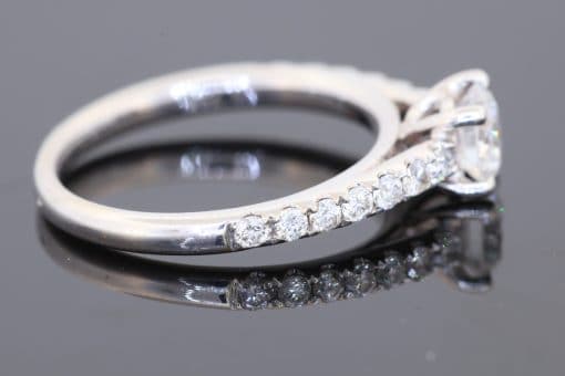 A timeless diamond engagement ring, combining the brilliance of a round brilliant-cut centre diamond with the refined sparkle of diamond-set shoulders. Crafted in 18kt white gold, this elegant design offers a sophisticated expression of enduring commitment.
