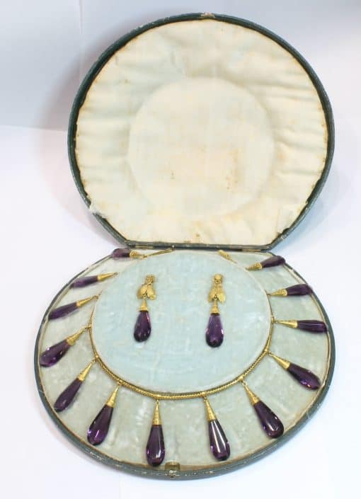 A spectacular antique amethyst parure, made in Italy circa 1880. An impressive suite of matching jewellery, showcasing the rich violet beauty of amethyst and the elaborate craftsmanship characteristic of late 19th-century Italian jewellery. Parures were particularly prized for their coordinated design, with matching pieces intended to be worn together for formal occasions. This exceptional suite is a wonderful example of the Victorian fascination with richly coloured gemstones and grand, coordinated jewels.