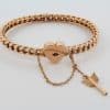 A rare antique 15-karat gold bangle, distinguished by its romantic heart lock and Cupid’s arrow key. Combining symbolic motifs of love and devotion with the enduring appeal of antique gold jewellery, this charming piece offers a glimpse into the sentimental traditions of earlier jewellery design.