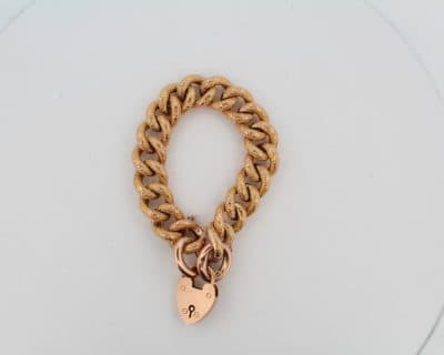 This Victorian curb bracelet combines the enduring appeal of traditional gold chainwork with the distinctive character of a night and day pattern. Its substantial links and warm gold tones reflect the decorative craftsmanship and practical elegance of Victorian jewellery.