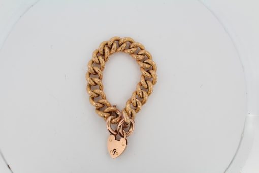 This Victorian curb bracelet combines the enduring appeal of traditional gold chainwork with the distinctive character of a night and day pattern. Its substantial links and warm gold tones reflect the decorative craftsmanship and practical elegance of Victorian jewellery.