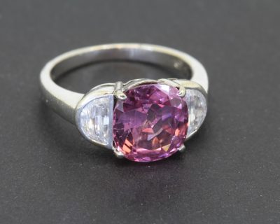 A superb spinel and diamond ring, centred on a magnificent 5-carat spinel from Sri Lanka. Confirmed as unheated, this exceptional gemstone retains its natural character, making it particularly appealing to the discerning coloured gemstone collector. Sri Lanka has a long-standing reputation for producing fine coloured gemstones, and its spinels are prized for their beauty and individuality.