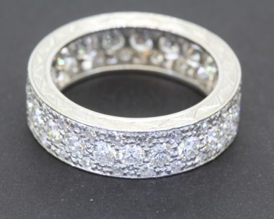 A rare antique diamond full eternity ring, distinguished by its substantial diamond weight and beautifully engraved sides. Combining the enduring brilliance of diamonds with the artistry of hand-engraved detailing, this is a characterful antique jewel with timeless appeal.
