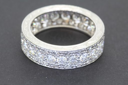 A rare antique diamond full eternity ring, distinguished by its substantial diamond weight and beautifully engraved sides. Combining the enduring brilliance of diamonds with the artistry of hand-engraved detailing, this is a characterful antique jewel with timeless appeal.