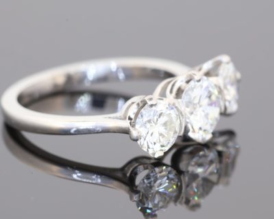 Elegant and timeless, this three-stone diamond ring combines the enduring beauty of diamonds with the refined sophistication of platinum. At its centre is a striking 0.91-carat diamond, graded E colour and SI1 clarity, complemented by two additional diamonds to create a beautifully balanced design with an impressive total diamond weight of 1.97 carats.