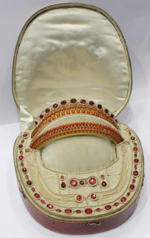 A remarkable antique parure of coral, garnet, cultured pearl, 18kt gold and gilded metal, associated with the Countess du Durat. An extraordinary and highly unusual suite comprising three tiaras, a necklace, a pair of ear pendants, a pair of ear clips and two bracelets. The parure is particularly evocative for its aristocratic association and the extraordinary breadth of the suite. The Comtesses de Durat belonged to a lineage whose history extended through one of the most turbulent periods of French history, navigating the upheavals of the French Revolution before re-establishing their position within aristocratic society during the Napoleonic era. The family also had a Caribbean branch connected with French colonial administration in territories including Grenada and Saint Martin, while members of the family in mainland France maintained important estates and family residences. Among the women associated with the lineage were Jeanne-Caroline de Patouillet de Deservillers and Marie Marguerite Henriette de Durat, figures remembered in regional records for their cultivation and erudition.