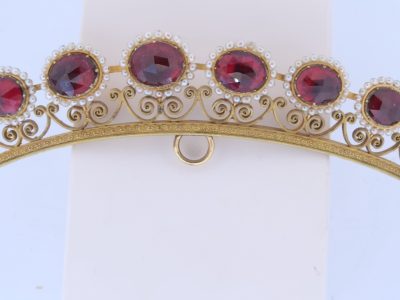 A remarkable antique parure of coral, garnet, cultured pearl, 18kt gold and gilded metal, associated with the Countess du Durat. An extraordinary and highly unusual suite comprising three tiaras, a necklace, a pair of ear pendants, a pair of ear clips and two bracelets. The parure is particularly evocative for its aristocratic association and the extraordinary breadth of the suite. The Comtesses de Durat belonged to a lineage whose history extended through one of the most turbulent periods of French history, navigating the upheavals of the French Revolution before re-establishing their position within aristocratic society during the Napoleonic era. The family also had a Caribbean branch connected with French colonial administration in territories including Grenada and Saint Martin, while members of the family in mainland France maintained important estates and family residences. Among the women associated with the lineage were Jeanne-Caroline de Patouillet de Deservillers and Marie Marguerite Henriette de Durat, figures remembered in regional records for their cultivation and erudition.