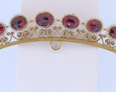 A remarkable antique parure of coral, garnet, cultured pearl, 18kt gold and gilded metal, associated with the Countess du Durat. An extraordinary and highly unusual suite comprising three tiaras, a necklace, a pair of ear pendants, a pair of ear clips and two bracelets. The parure is particularly evocative for its aristocratic association and the extraordinary breadth of the suite. The Comtesses de Durat belonged to a lineage whose history extended through one of the most turbulent periods of French history, navigating the upheavals of the French Revolution before re-establishing their position within aristocratic society during the Napoleonic era. The family also had a Caribbean branch connected with French colonial administration in territories including Grenada and Saint Martin, while members of the family in mainland France maintained important estates and family residences. Among the women associated with the lineage were Jeanne-Caroline de Patouillet de Deservillers and Marie Marguerite Henriette de Durat, figures remembered in regional records for their cultivation and erudition.