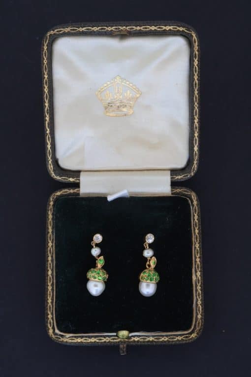 A superb pair of natural pearl and demantoid garnet drop earrings, presented in their original fitted case. The combination of natural pearls and vivid green demantoid garnets creates a particularly elegant and distinctive pairing, with the original case adding to their appeal and historical character.