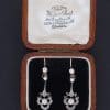 A beautiful pair of antique Belle Époque diamond and pearl drop earrings, dating to circa 1910. Elegant and refined, they capture the graceful femininity of the period, when delicate diamond jewellery and the soft lustre of pearls were particularly fashionable.