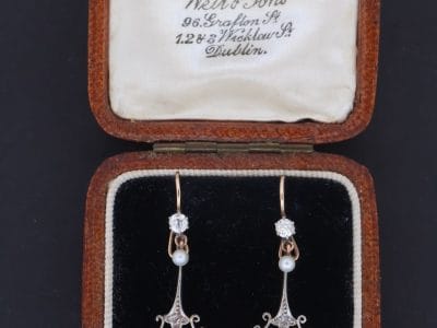 A beautiful pair of antique Belle Époque diamond and pearl drop earrings, dating to circa 1910. Elegant and refined, they capture the graceful femininity of the period, when delicate diamond jewellery and the soft lustre of pearls were particularly fashionable.